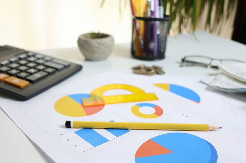 Blogger writing zero-based budget worksheet at desk with calculator and notebook